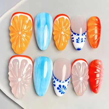 Handmade press-on nails with orange, pink, blue, and floral fruit-inspired designs