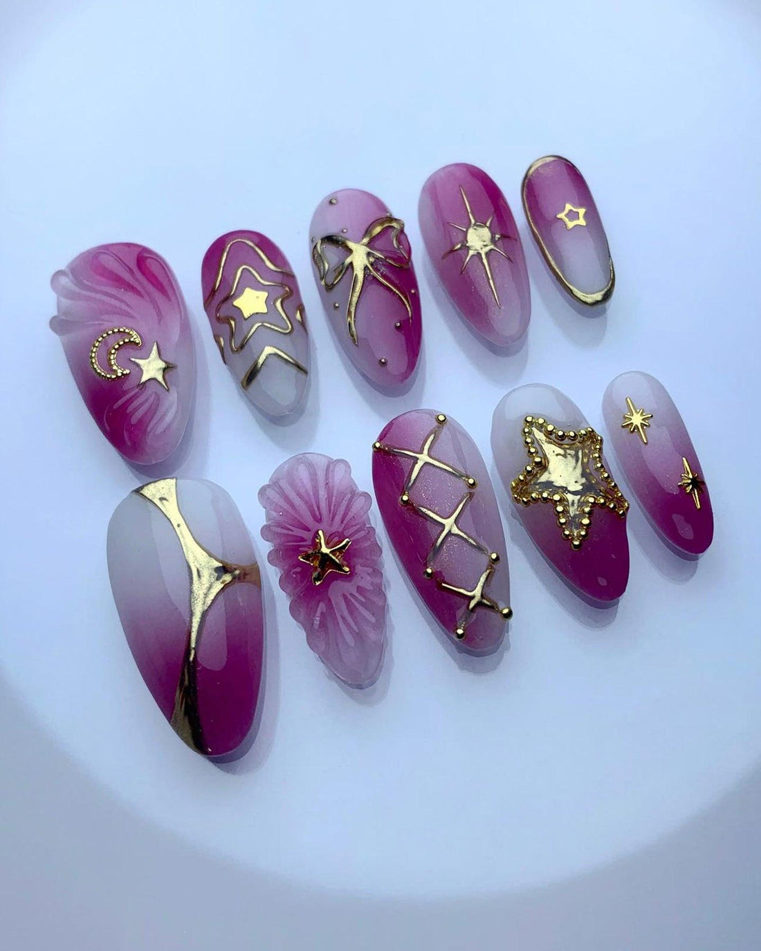 Handmade pink and white press-on nails with gold star and moon designs, celestial accents