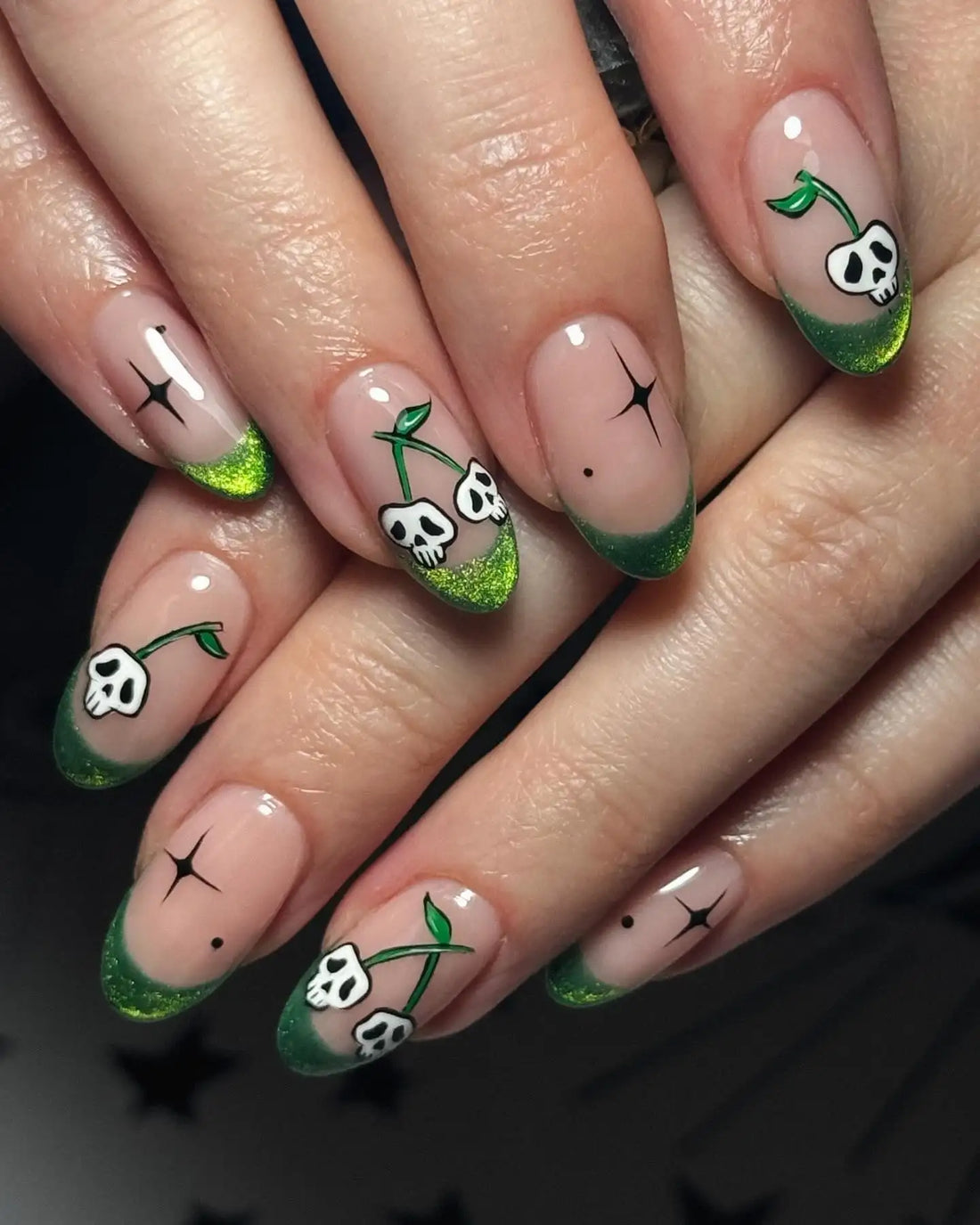 Handmade green glitter press-on nails with skull and star nail art design