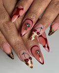 Stiletto press-on nails with cherry art, cross charms, brown marble tips and red abstract designs