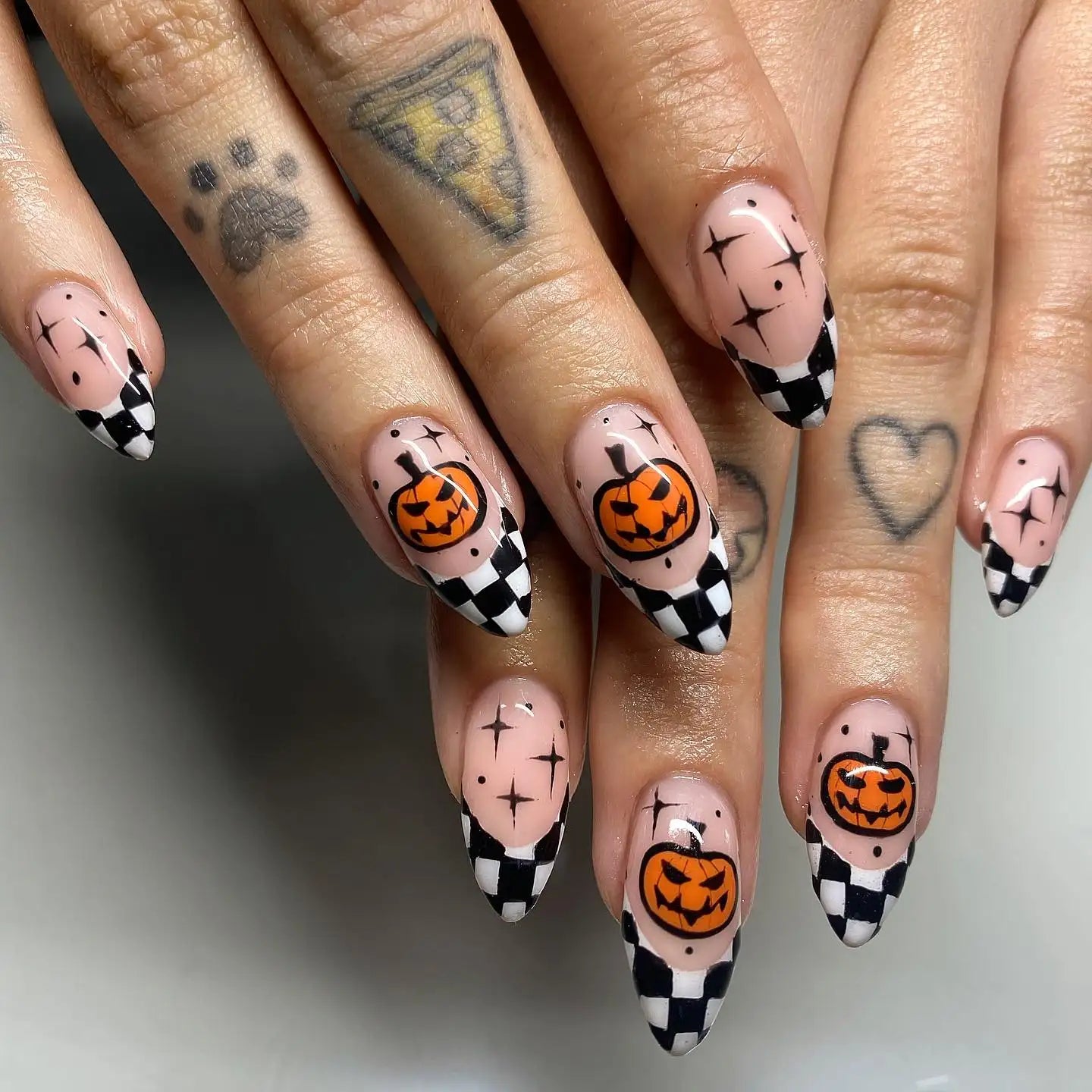 Halloween press-on nails with jack-o'-lanterns, black and white checker tips, and star accents