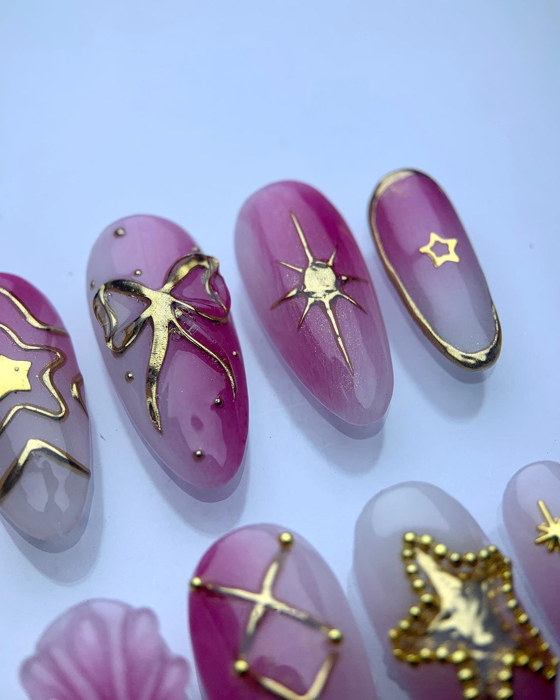 Handmade pink and white press-on nails with gold star and moon designs, celestial accents