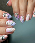 Handmade press-on nails with pastel Halloween designs, ghosts, pumpkins, and 'boo' text.