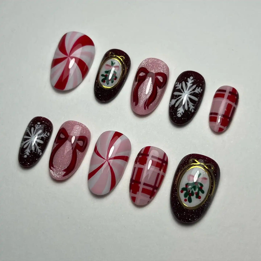 Handmade Christmas press-on nails with candy cane, plaid, bow, snowflake, and holly designs