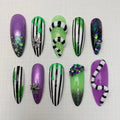 Halloween press-on nails with Beetlejuice-inspired green, purple, and black designs, glitter, spider webs, and gemstone accents.