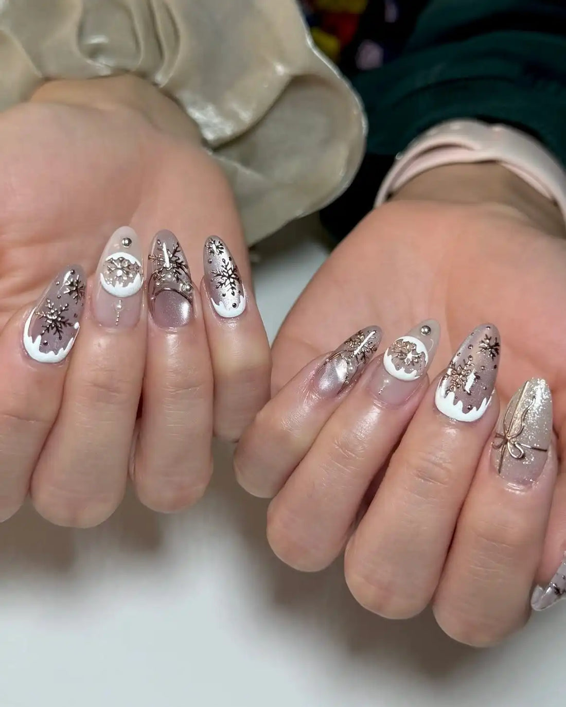Handmade press-on nails with white tips, snowflake designs and rhinestone accents