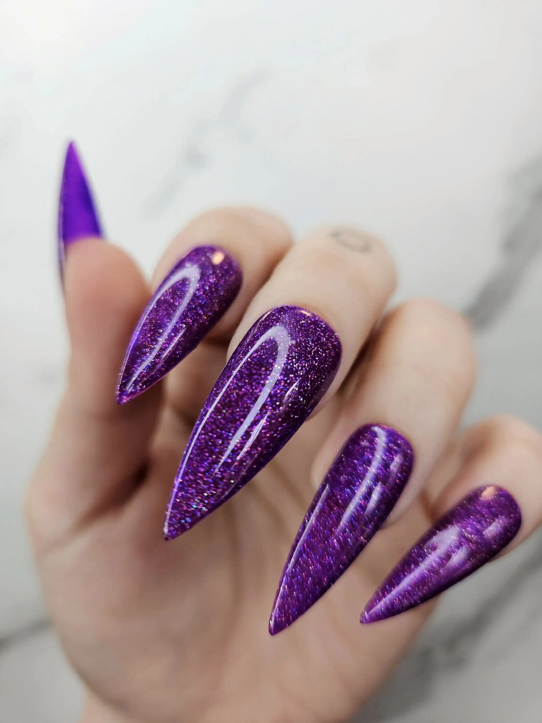 Long stiletto press-on nails with deep amethyst purple glitter and glossy finish
