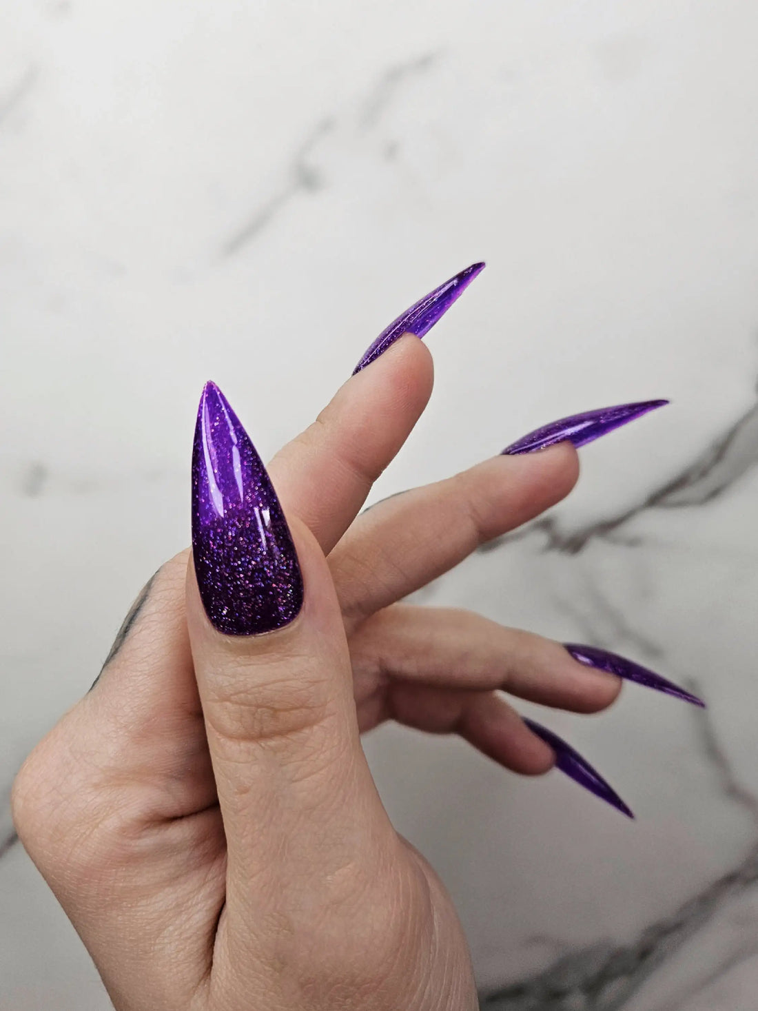 Long stiletto press-on nails with deep amethyst purple glitter and glossy finish