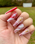 Red Christmas press-on nails with glitter, snowflakes, stars, and candy cane designs