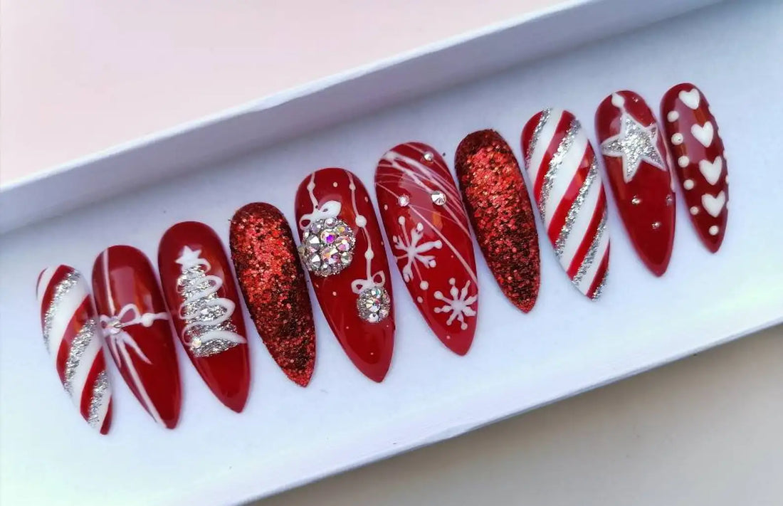 Red Christmas press-on nails with glitter, snowflakes, stripes, and festive holiday designs.