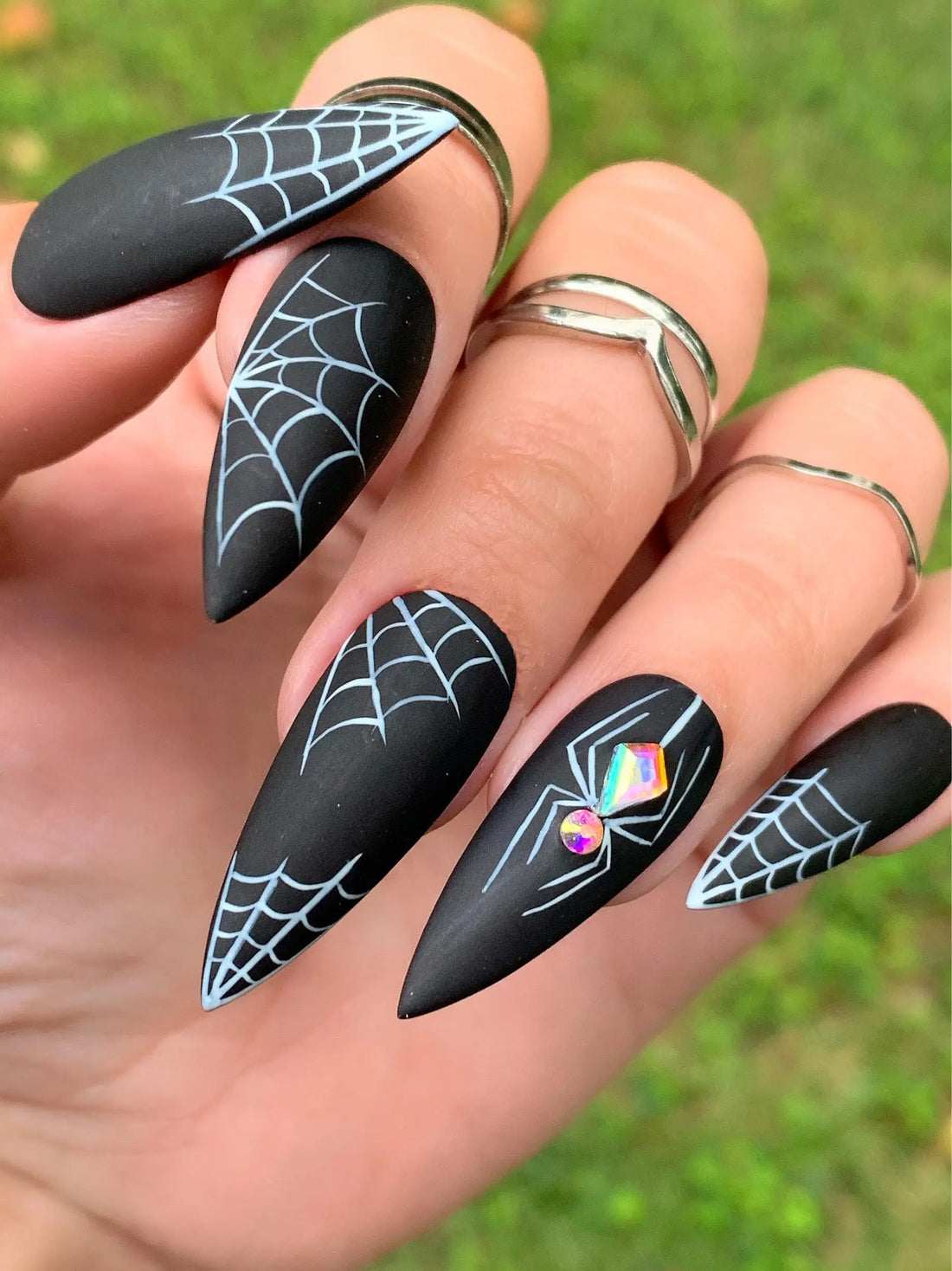 Halloween press-on nails with black matte finish, white spider webs, and sparkle gem spider design.