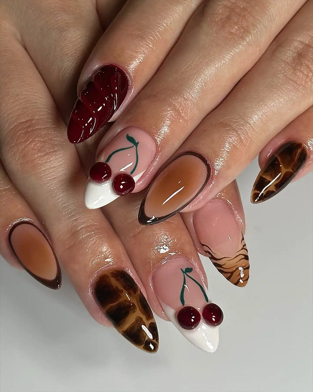 Handmade 3D press-on nails with cherry accents, chocolate brown, and tortoise shell animal print.