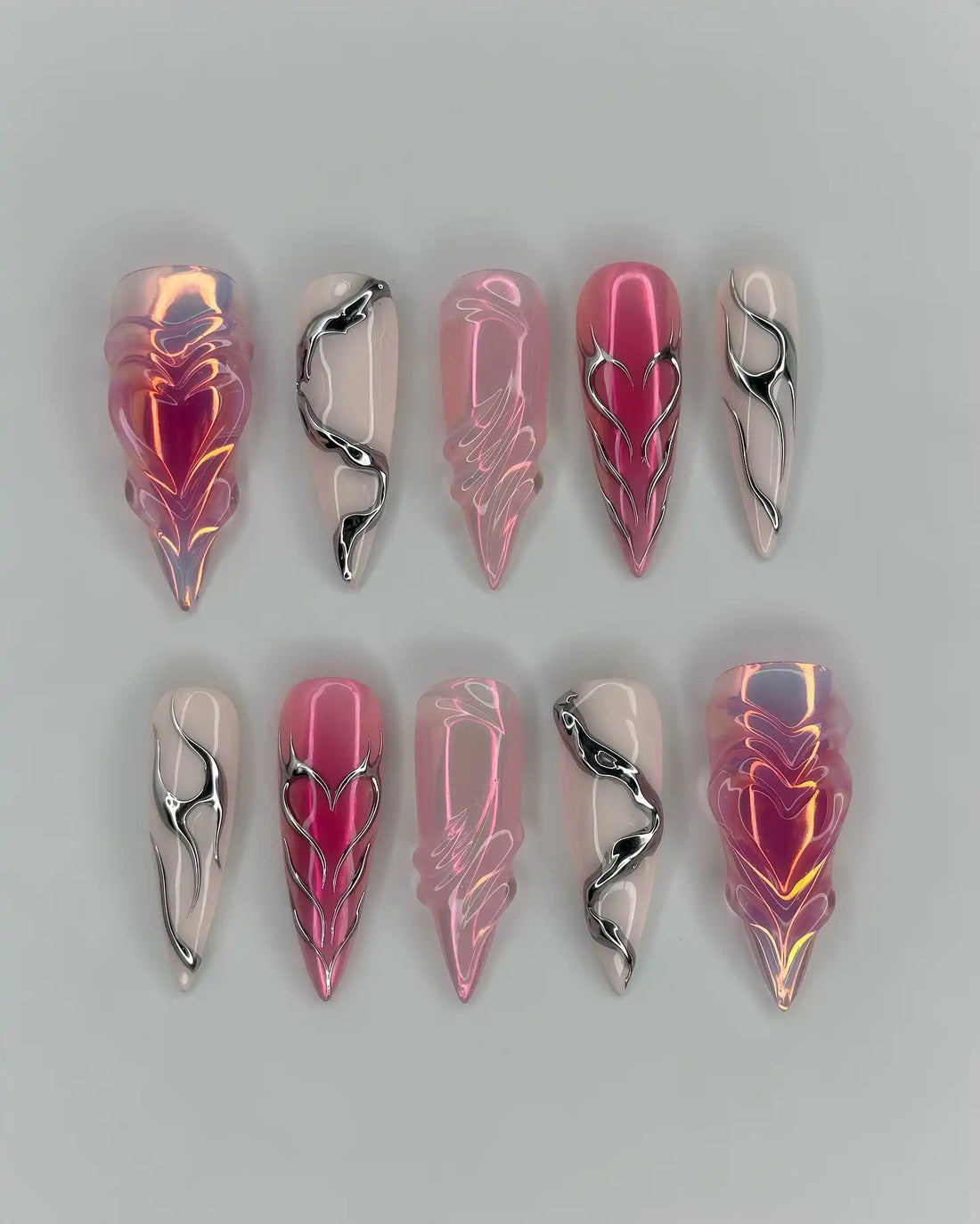 Handmade pink chrome press-on nails with heart, snake, and grunge Y2K designs.