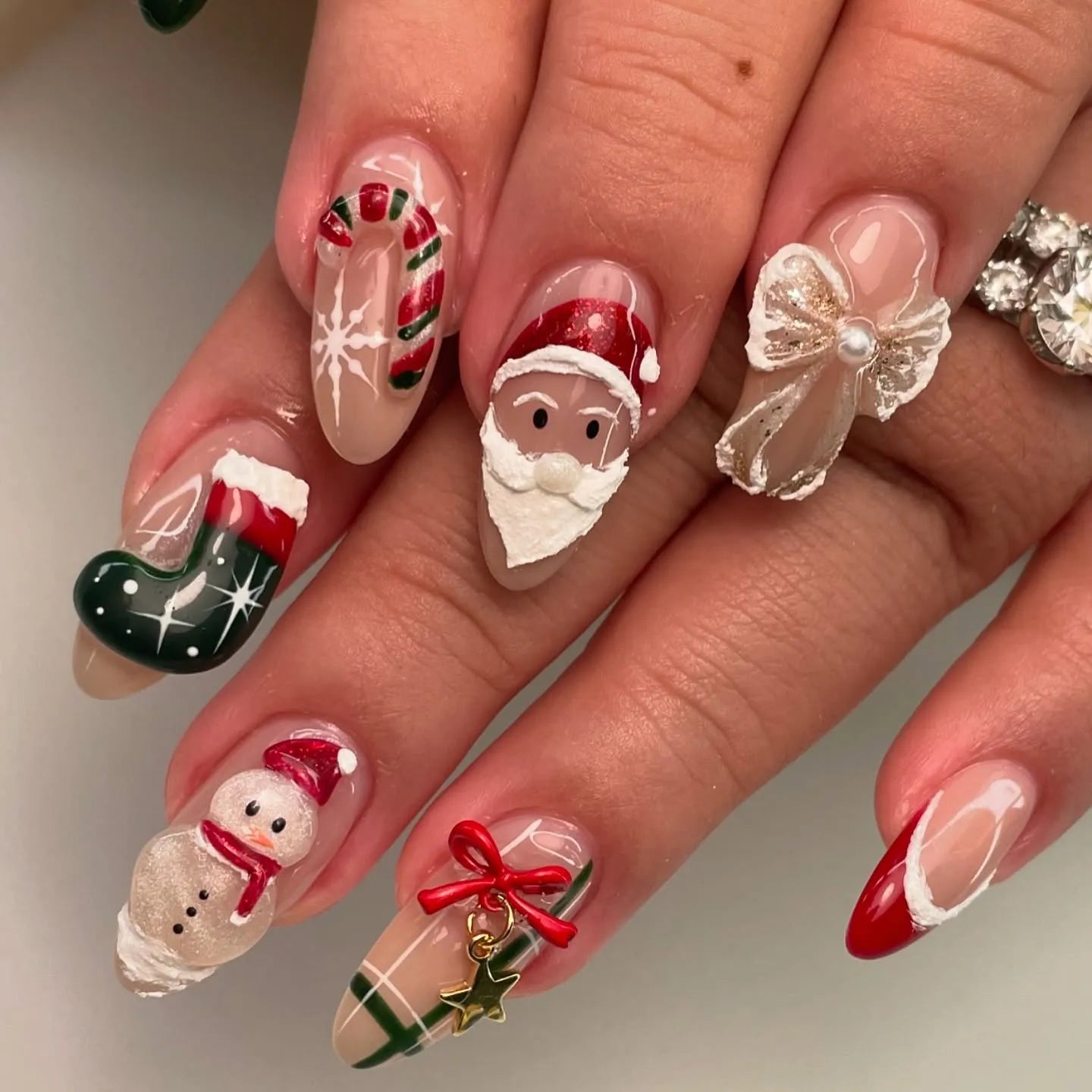 Handmade Christmas press-on nails with Santa, snowman, candy cane, and holiday decorations