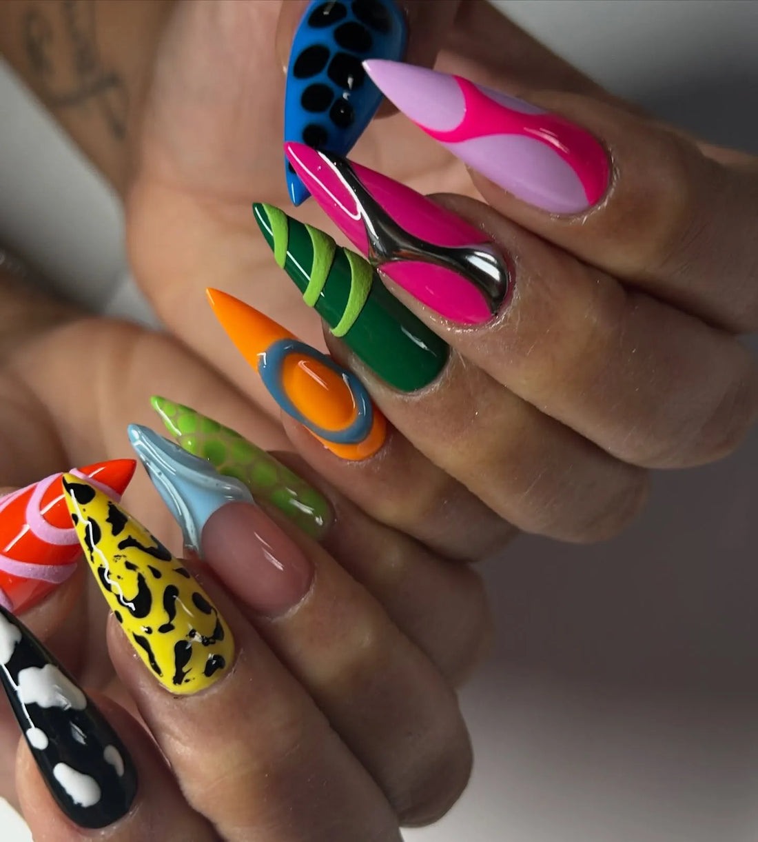 Handmade stiletto press-on nails with neon, abstract, 3D, and animal print designs.