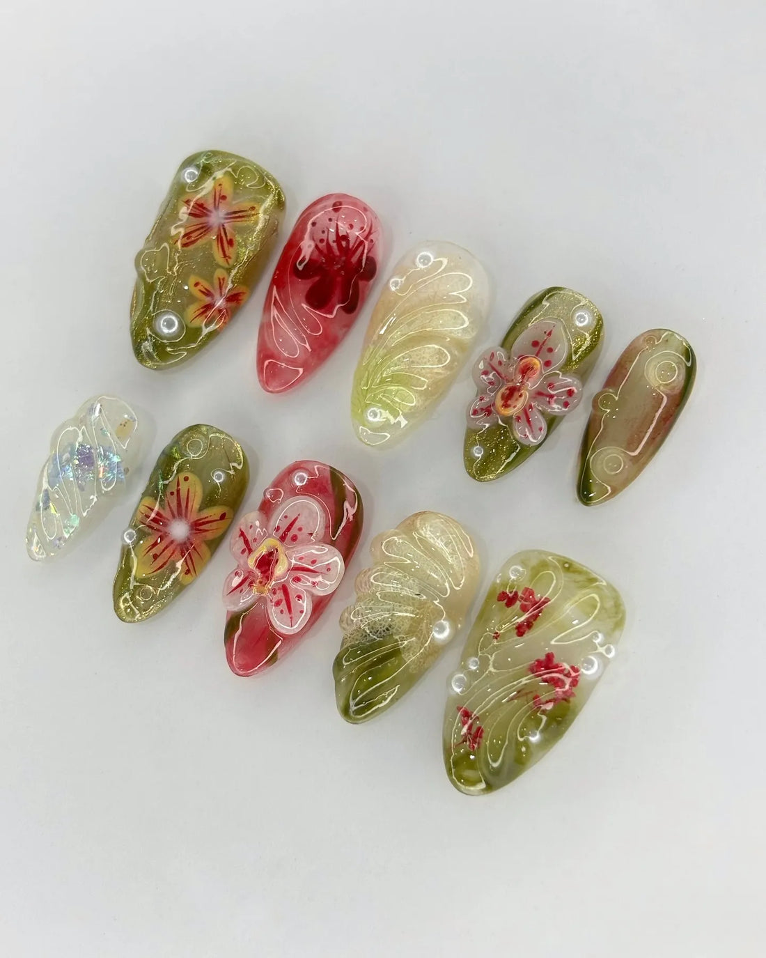 Handmade press-on nails with 3D pink orchid floral design, green and gold accents, and pearl details