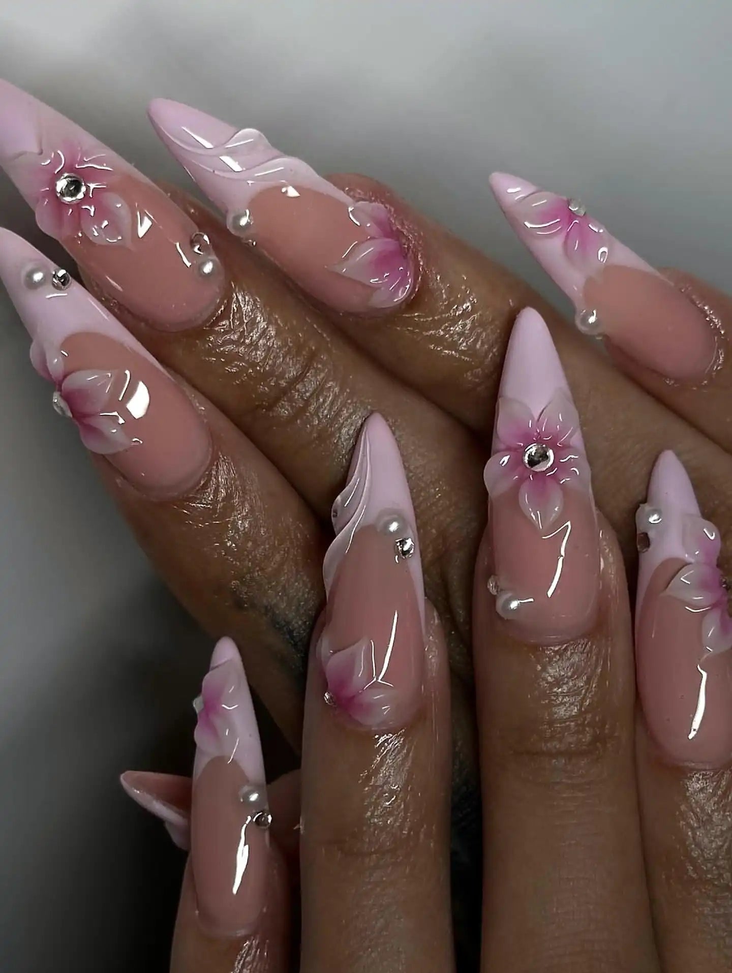 Handmade pink French tip press-on nails with 3D floral designs and pearl accents