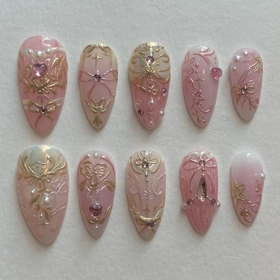 Handmade pink press-on nails with gold baroque filigree, rhinestones, and pearl accents