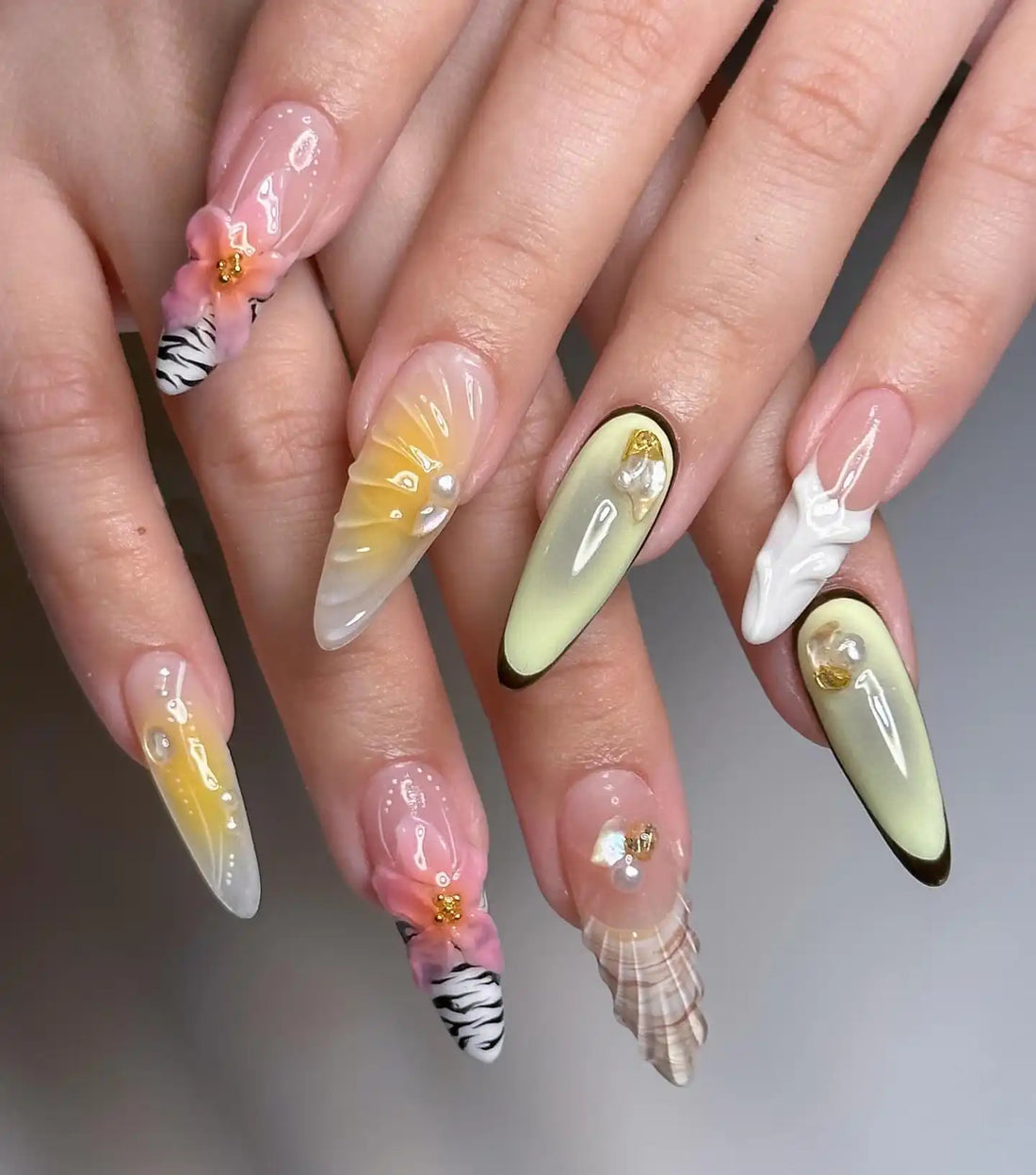 Handmade press-on nails with seashell, floral, and zebra patterns in pastel colors