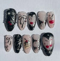 Handmade press-on nails with black and pink designs, cherries, bows, pearls, and glitter accents.