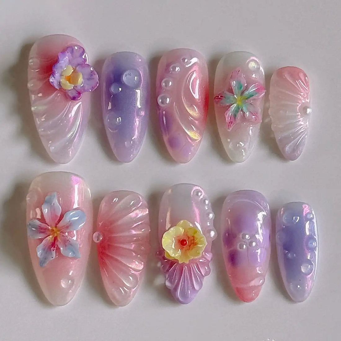 Handmade pink ombre press-on nails with 3D floral designs and pearl accents