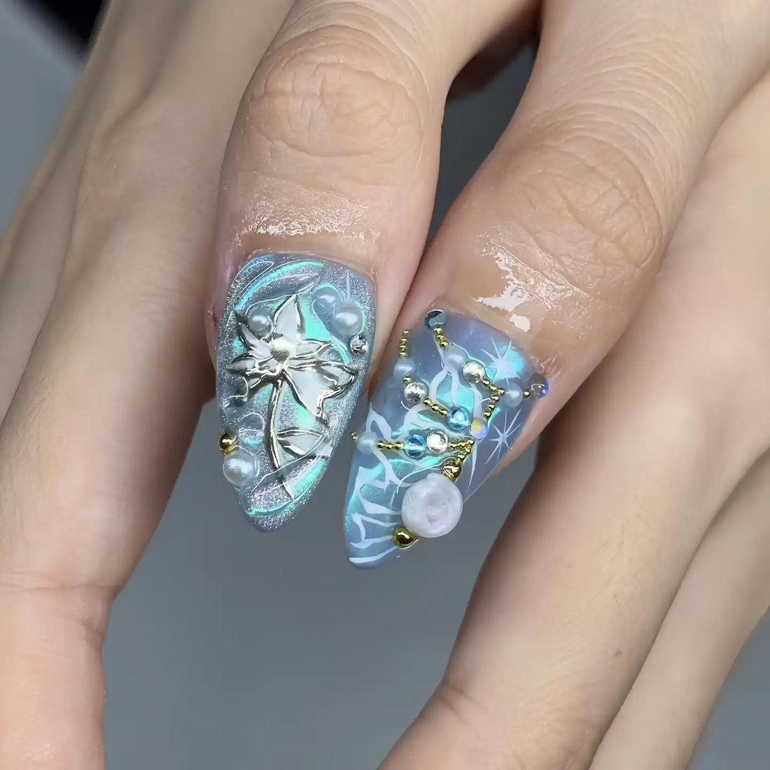 Handmade blue press-on nails with starfish, seashell, and pearl ocean-themed 3D designs.