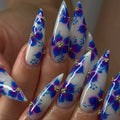 Handmade stiletto press-on nails with blue and purple watercolor floral design and gold accents