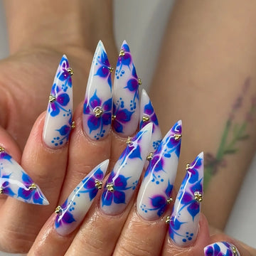 Handmade stiletto press-on nails with blue and purple floral watercolor art and gold accents