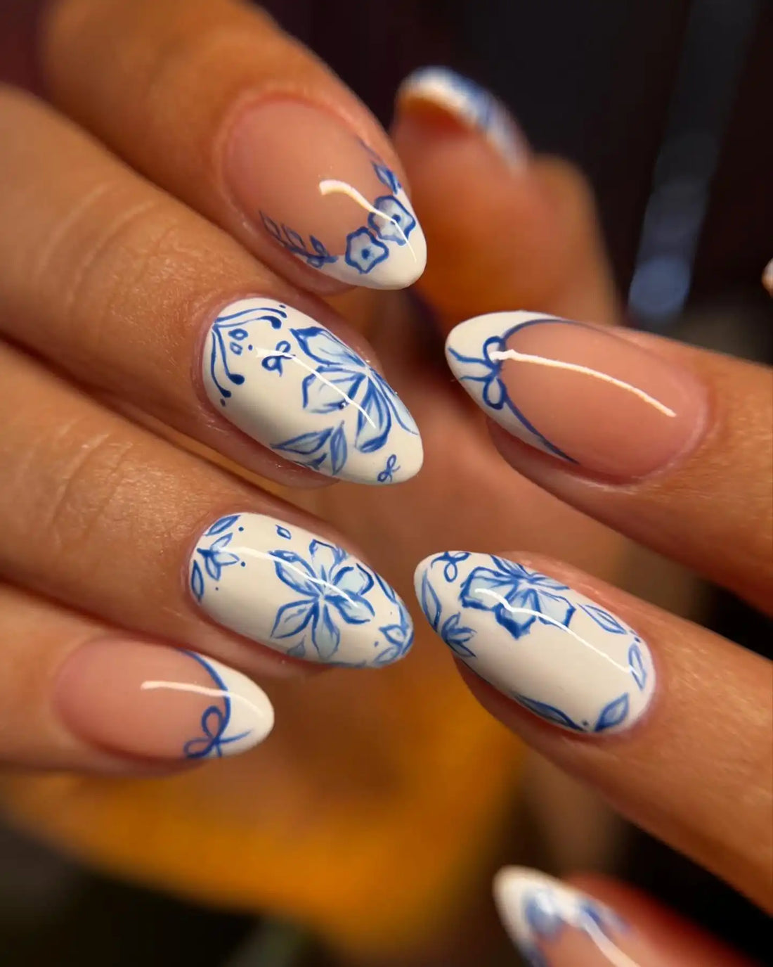 Handmade blue and white floral press-on nails with elegant almond shape design.