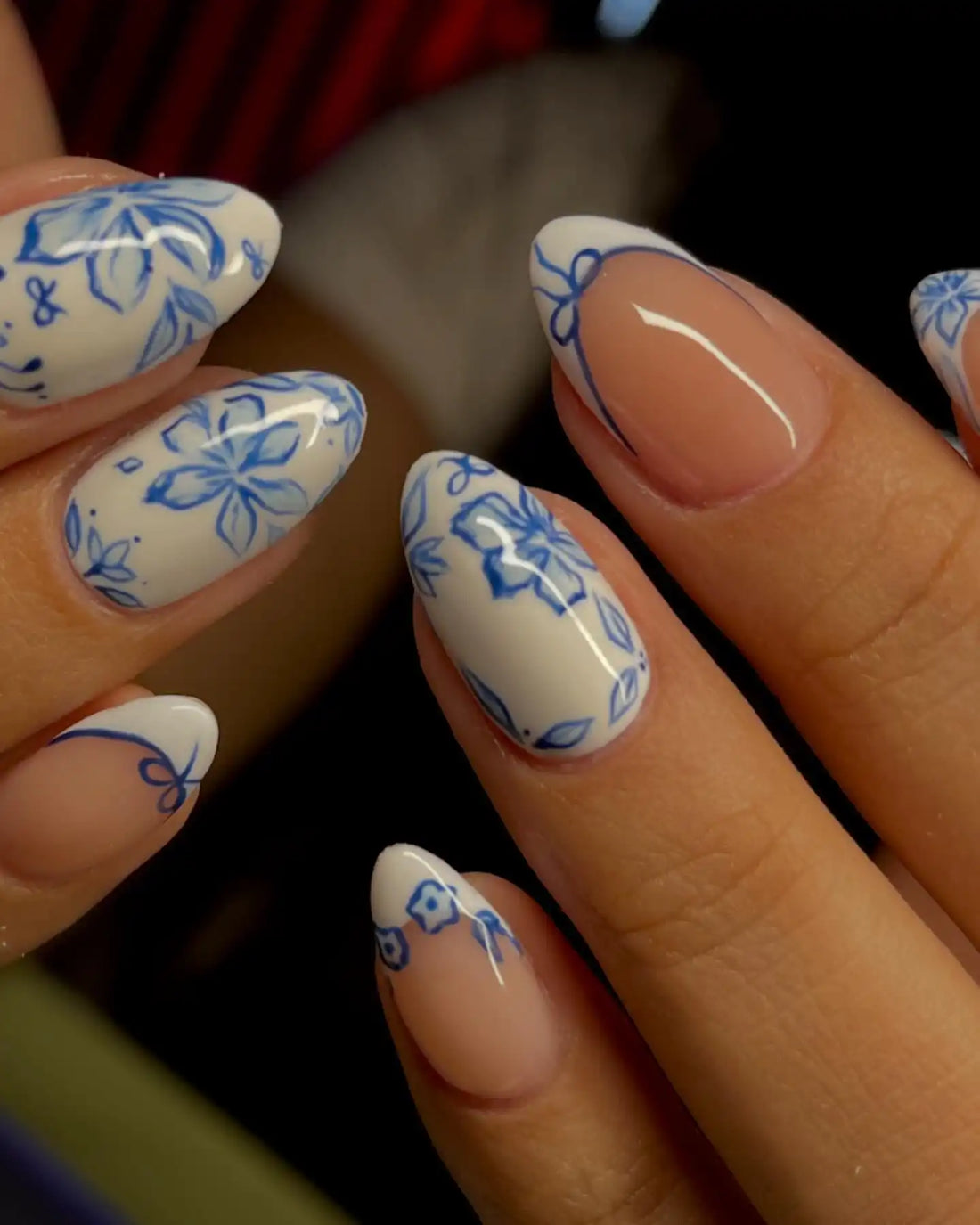 Handmade blue and white floral press-on nails with elegant almond shape design.