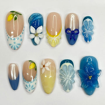 Handmade blue and yellow floral summer press-on nails with 3D lemon and flower designs.