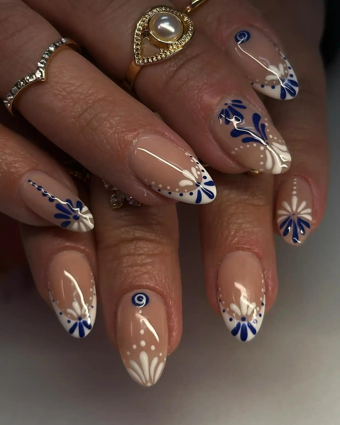 Handmade blue and white floral dot glossy press-on nails with intricate patterns.