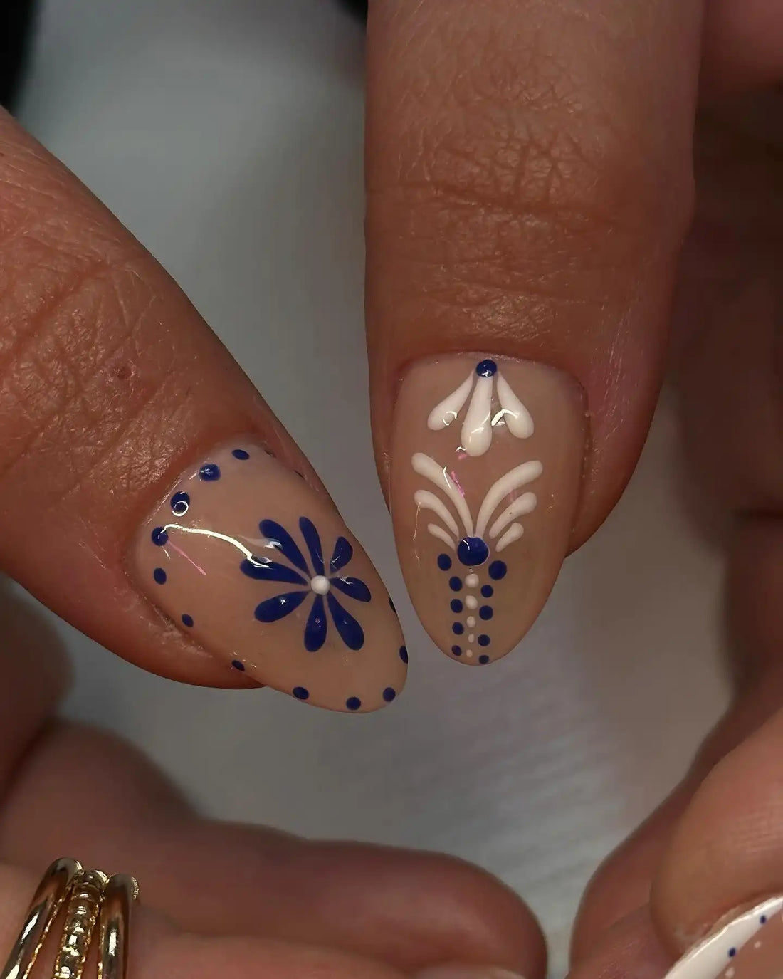Handmade blue and white floral dot glossy press-on nails with intricate patterns.