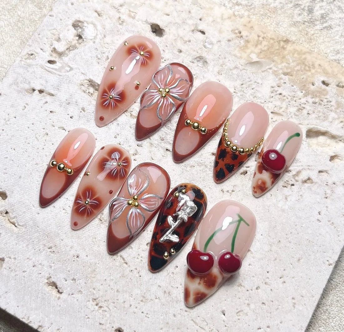 Handmade press-on nails with brown leopard, cherry, floral, and gemstone 3D designs
