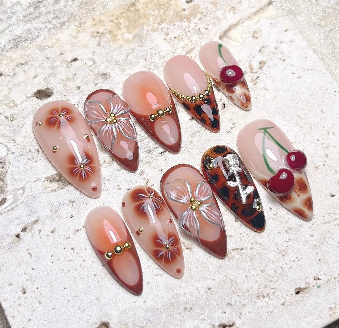 Handmade press-on nails with brown leopard, cherry, floral, and gemstone 3D designs