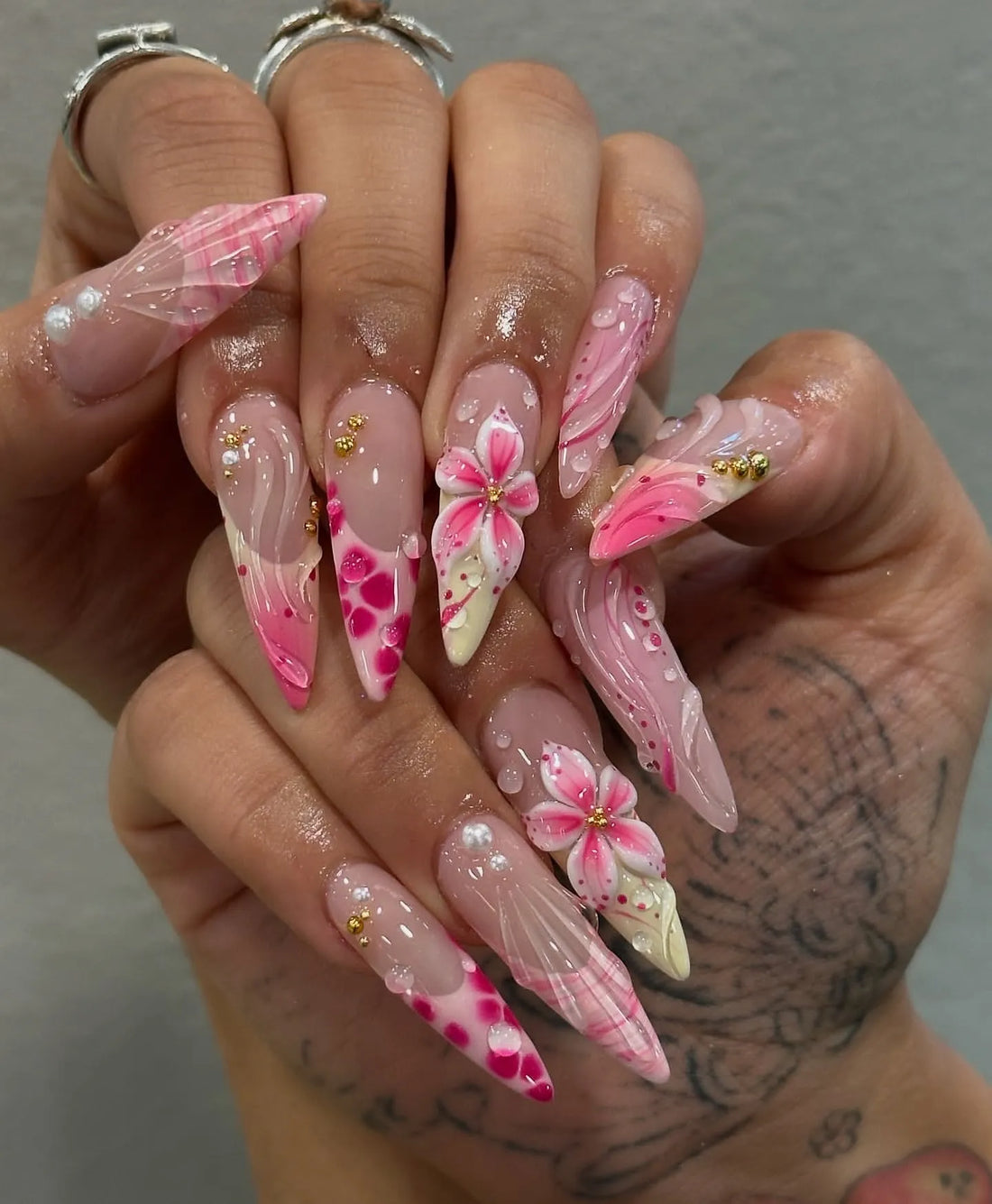 Handmade bubblegum pink stiletto press-on nails with 3D floral designs and gold accents