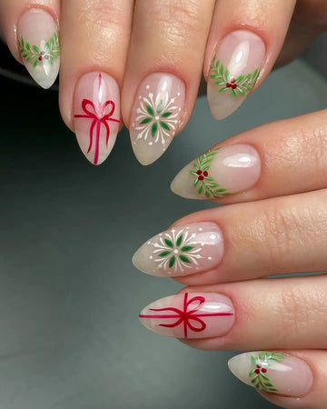 Handmade press-on nails with Christmas designs, holly berries, ribbon bows, and snowflake art