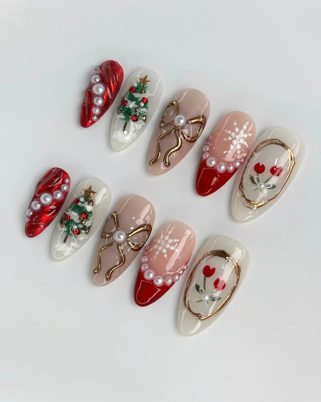 Handmade festive press-on nails with Christmas tree, bow, pearl, and red white holiday designs