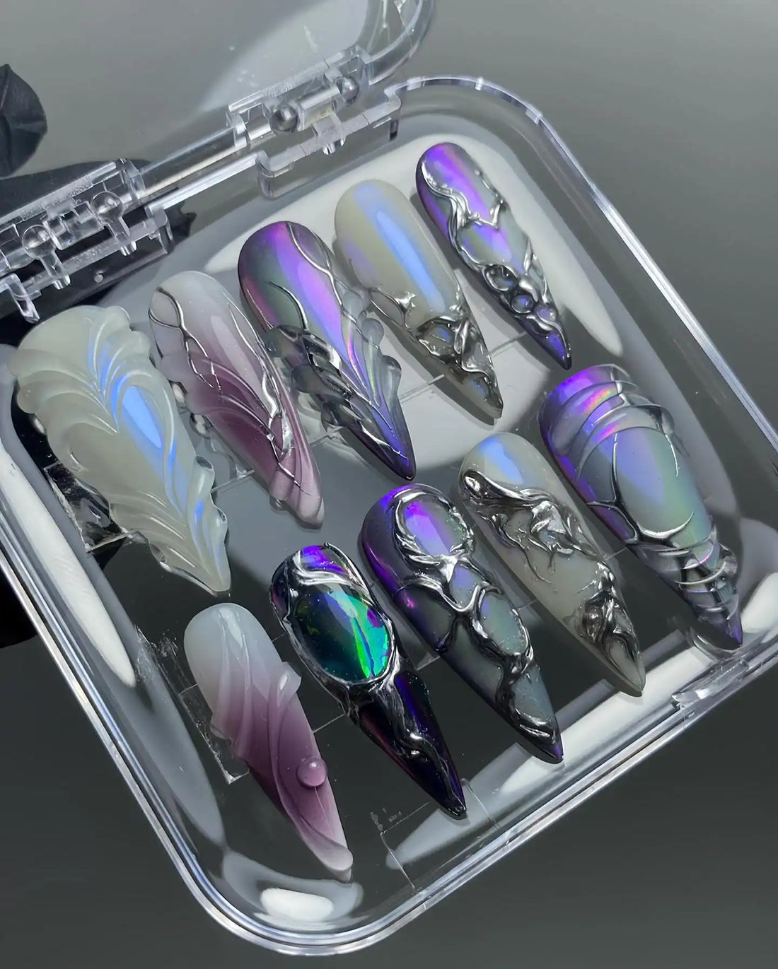 Handmade press-on nails with chrome, black, and iridescent purple abstract sci-fi designs