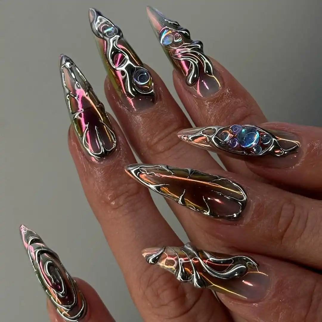 Hand with long handmade chrome silver press-on nails featuring sculpted 3D designs