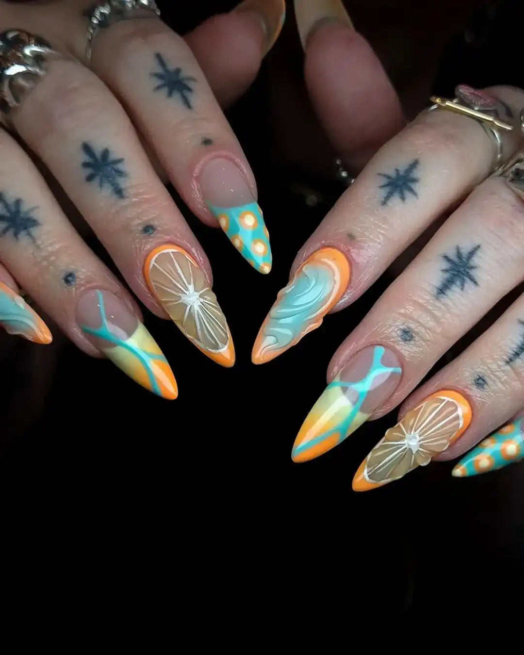 Handmade press-on nails with citrus orange slices, aqua swirls, and retro summer patterns