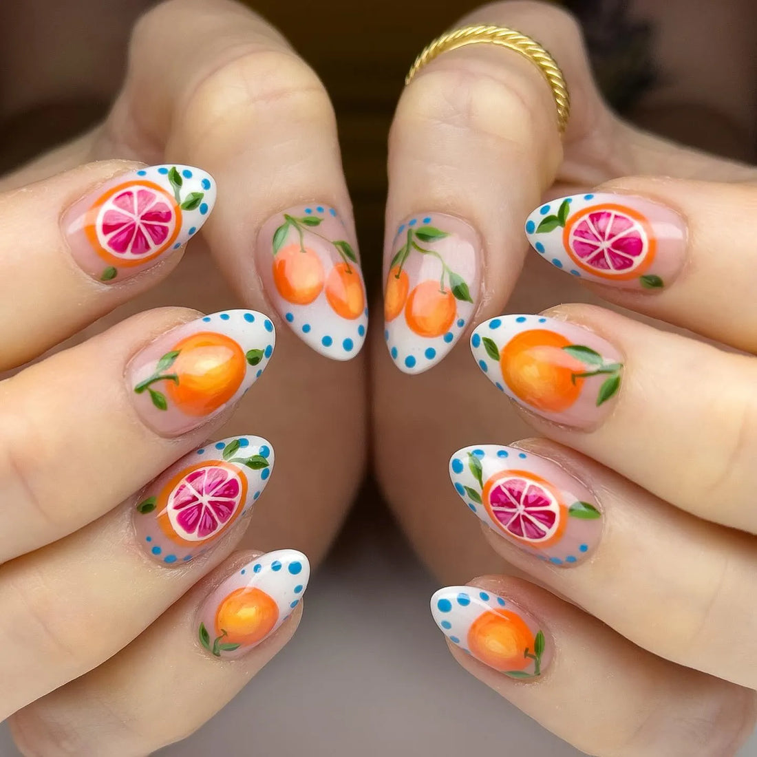 Handmade press-on nails with orange and grapefruit fruit art, summer-themed nail design.