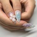 Hand with handmade clear press-on nails featuring 3D flower and butterfly spring designs