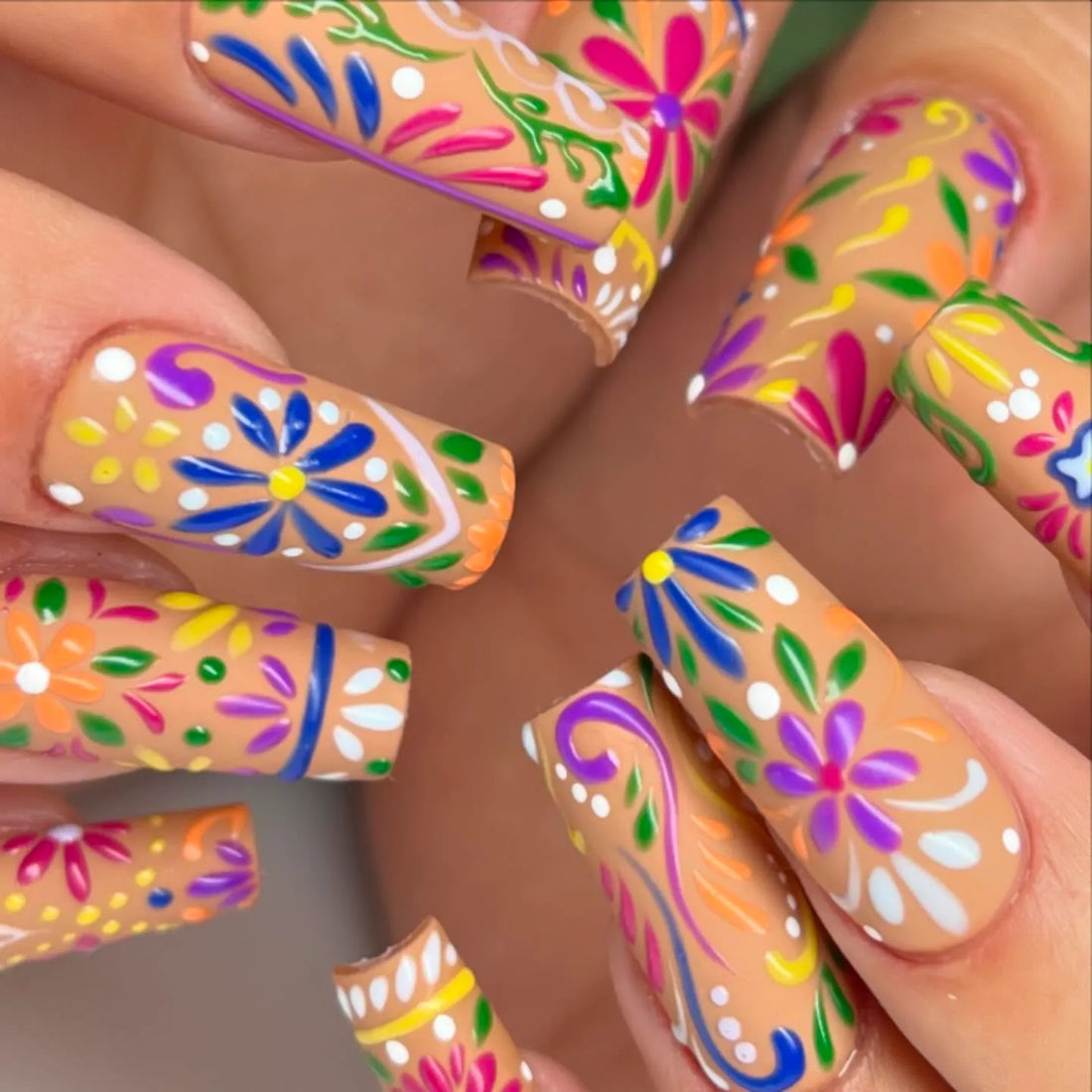 Handmade press-on nails with vibrant, colorful folk art floral summer designs.