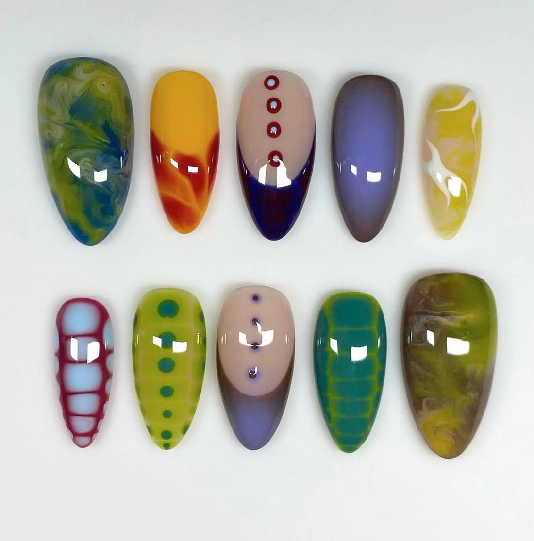 Handmade colorful graffiti press-on nails with abstract and geometric patterns on white background
