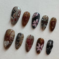 Handmade press-on nails with dark academia floral and butterfly designs in moody brown and gray tones.