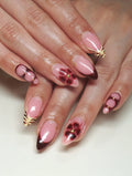 Handmade press-on nails with dark cherry French tips, floral and tiger print accents.
