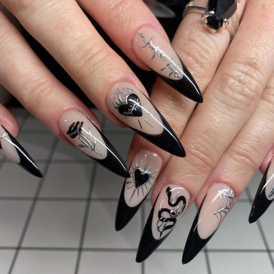 Handmade gothic press-on nails with black French tips, heart, rose, spiderweb, and silver accents.
