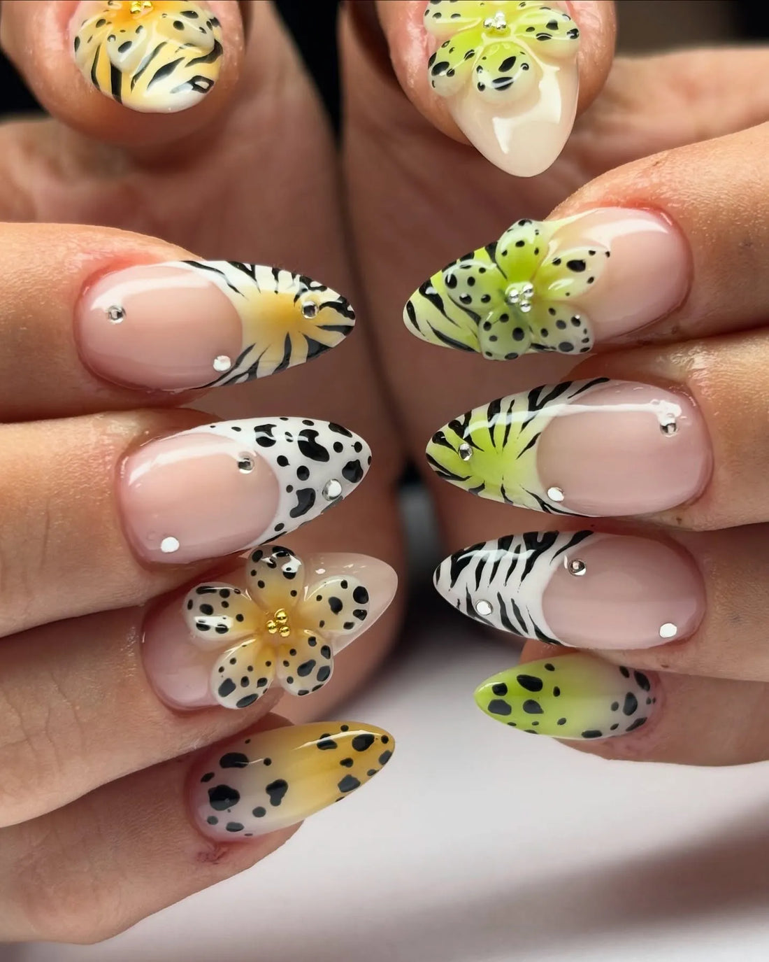 Handmade press-on nails with floral 3D accents, leopard print, zebra stripes, and crystal details.