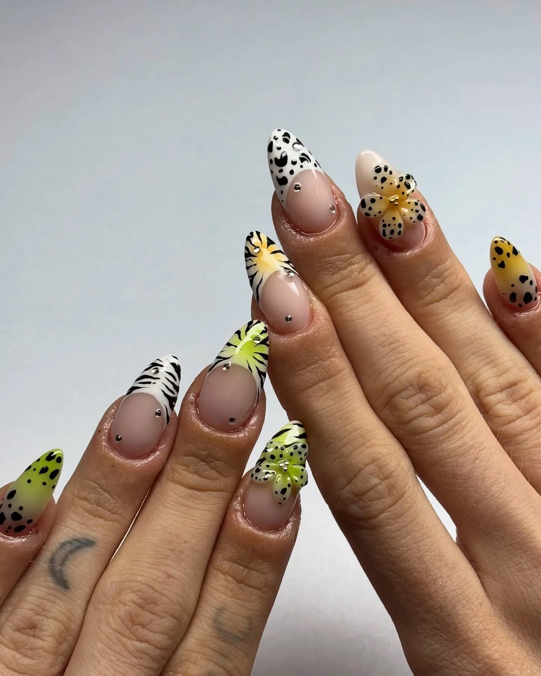 Handmade press-on nails with floral 3D accents, leopard print, zebra stripes, and crystal details.